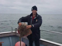 Angler holding up a Thornback Ray