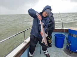 An Angler holding up small Starry Smooth-Hound