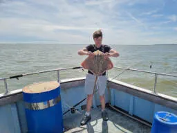 An Angler holding up Thornback Ray
