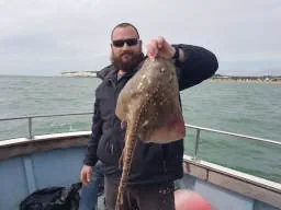 An Angler holding up a Thornback-Ray