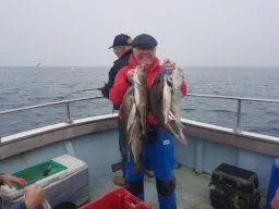 Angler holding up several Codling